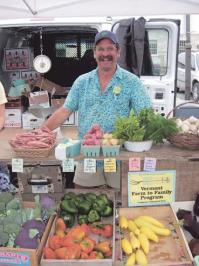 Will Stevens, owner of Golden Russet Farm, smiles throughout the hustle and bustle of the busy Middlebury Farmers Market Saturday, September 16th.