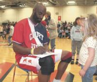 Sayeed Abdul-Muntaqim (a.k.a. Rainbow)  autographs a program for a young fan during halftime of The Court Jesters Comedy Basketball benefit game on 3-16-07 at MUHS.
The Jesters and Police Explorers enjoyed a great game. The fans got to sing, dance and interact with all the players. The Jesters have played similar games all over the world. For more info see www.cjesters.com.