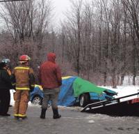 Fire fighters stand by as a vehicle containing the bodies of three victims is winched onto a tow truck. The two vehicle accident occurred on Wednesday Morning February 13th, 2008 on U.S. Route 7 just north of Exchange St.