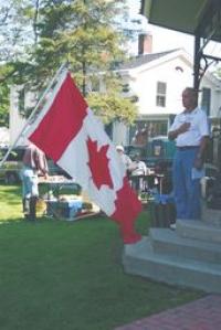 Vergennes Mayor Mike Daniels welcomes all to the French Heritage Day and stands at attention for the presentation of the French Flag and the playing of the French national anthem by Vergennes City Band, led by Susan O’Daniel.