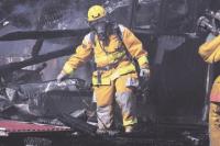 Salisbury firefighter sifts through debris at the scene of a barn fire in Salisbury on Aug. 19th. The blaze at the Nop Brothers and Sons cattle barn claimed the milking parlor but firefighters from six area departments saved the barn and 350 Holstein dairy cows.