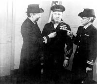 Preparing for a Naval inspection, Mr. Larrabee is assisted by two nurses.