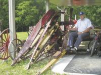 Al sits on the seat of a 1930’s corn harvester, which was pulled by horses and then
later by the Farmall H tractor.