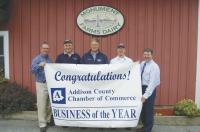 ACCOC Business of the Year banner is presented to Monument Farms Dairy, Weybridge, Vermont. From L to R: Andy Mayer, president, Addison County Chamber of Commerce; Bob James, vice president, sales and distribution; Peter James, vice president, farm operations; Jon Rooney, president; and Ted Shambo, membership director, Addison County Chamber of Commerce.
