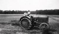 Riding on her dad Stanley’s lap, a young Helen learns how to drive the new steel tractor that came to the farm in 1936.
