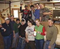 Staff , students and volunteers from the Lake Champlain Maritime Museum and  the Diversified Occupations Program of the Hannaford Career Center in Middlebury with the  32-foot pilot gig they are building.  Planking has been completed and ribs installed.