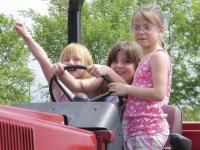 Celebrating the event, local children sit atop a tractor and dream of what they will plant!