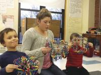 Educator Mary Nienow working with Hoberman spheres and two Mary Hogan Elementary School Students in the classroom.