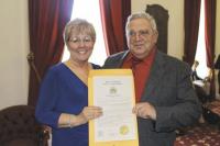 Cheryl White receives a copy of the resolution from Harvey Smith.