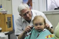 Seen here cutting Connor Desabrais hair for the first time, Bud Lundrigan was performing the same task that he had for five generations of this one Middlebury family. Just a day on the job for this 66 year part of downtown Middlebury and community member.