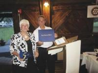 Rotarian Scott Gaines presents the Paul Harris Award to Sue Burdick honoring her commitment, service and devotion to Rotiarian causes.