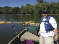 Michael Donnelly, Vergennes Rotarian puts the Rubber Ducks in Otter Creek for Saturday's Race.