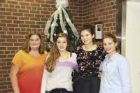 With a smile and enthusiasm, Coutney Morin, River Hoffman, Sophia Parker and Alyce Beauchemin pause after trimming the tree.