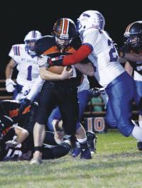 Cortland Fisher protects the ball as two Mt. Anthony move in for the tackle.