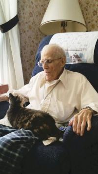 Max spends his days reading, visiting with people and holding his adored cat.