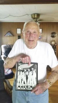 Proud of his service to his nation, George shows the image of himself serving in WWII.
