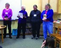 Local DAR members share a smile and some stories as they donate books to a local elementary school library.