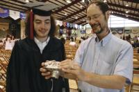 Matt Burkins (MUHS Class of 2011) and his Dad Chuck glance at a photo just taken and seem to be pleased that it is a keeper.  There were plenty of pictures being taken on this special day as members of the MUHS Class of 2011 gathered for the annual Commencement festivities held at the Memorial Sports Center in Middlebury on Saturday June 11th 2011.